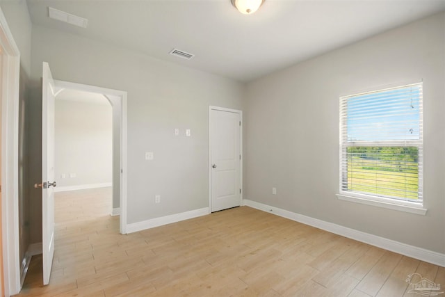 2665 Tulip Hill Rd, Pace, FL 32571 - unfurnished bedroom featuring light wood-style floors, baseboards, and arched walkways