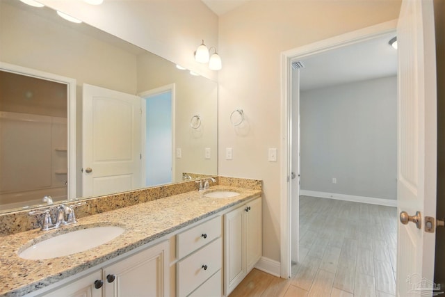 2665 Tulip Hill Rd, Pace, FL 32571 - bathroom featuring baseboards, double vanity, wood finished floors, and a tub to relax in