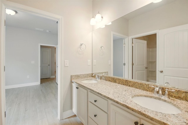2665 Tulip Hill Rd, Pace, FL 32571 - bathroom with double vanity, baseboards, and wood finished floors