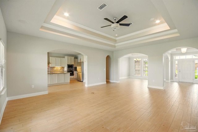 2665 Tulip Hill Rd, Pace, FL 32571 - unfurnished living room with a tray ceiling, a ceiling fan, light wood finished floors, baseboards, and crown molding