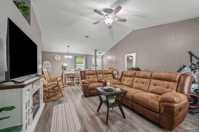 6856 Old W Ln, Milton, FL 32570 - living room featuring light wood-style floors, a ceiling fan, vaulted ceiling, a chandelier, and a textured ceiling