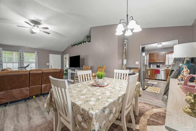 6856 Old W Ln, Milton, FL 32570 - dining area featuring light wood-type flooring, lofted ceiling, ceiling fan, a chandelier, and a textured ceiling
