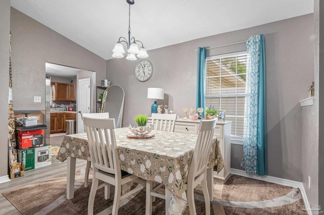 6856 Old W Ln, Milton, FL 32570 - dining room featuring lofted ceiling, light wood-style floors, a chandelier, and baseboards
