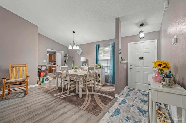 6856 Old W Ln, Milton, FL 32570 - dining space with wood finished floors, a textured ceiling, baseboards, vaulted ceiling, and a chandelier