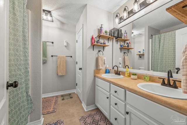 6856 Old W Ln, Milton, FL 32570 - full bath with double vanity, a textured ceiling, tile patterned floors, and baseboards