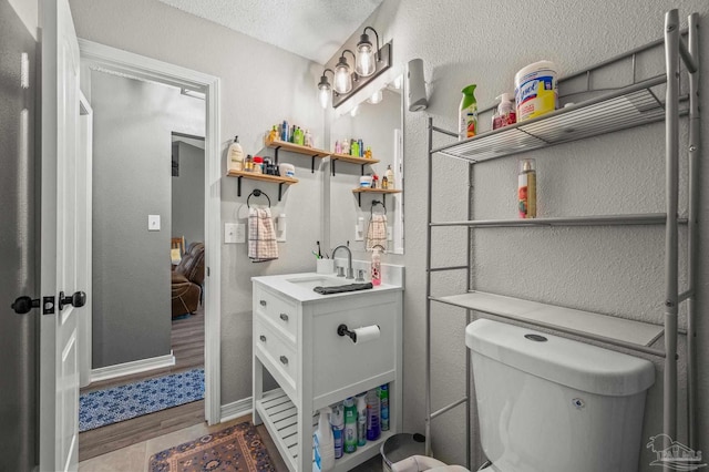 6856 Old W Ln, Milton, FL 32570 - bathroom with vanity, wood finished floors, a textured ceiling, toilet, and baseboards