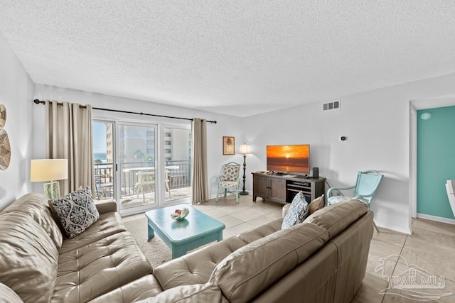 living room featuring light tile patterned floors and a textured ceiling
