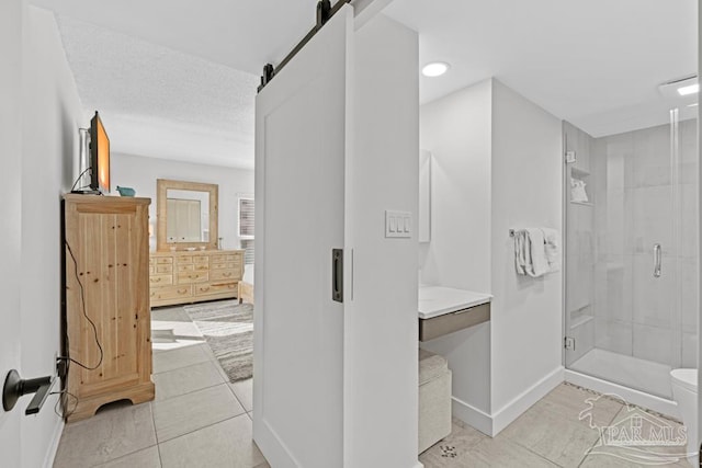 bathroom featuring tile patterned flooring, vanity, walk in shower, toilet, and a textured ceiling