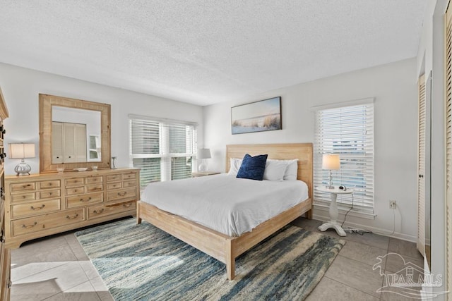 bedroom with a textured ceiling and light tile patterned flooring