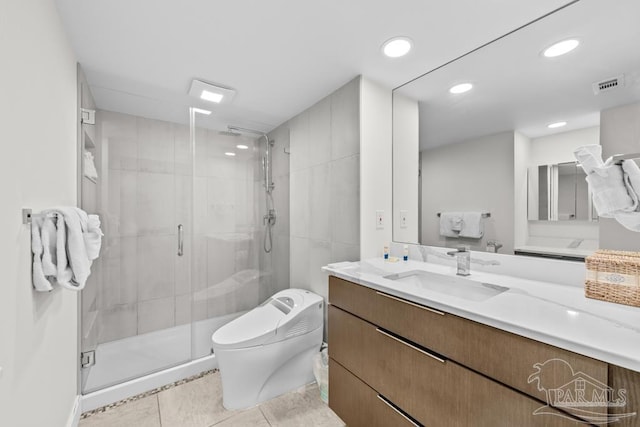 bathroom with tile patterned floors, vanity, toilet, and a shower with shower door