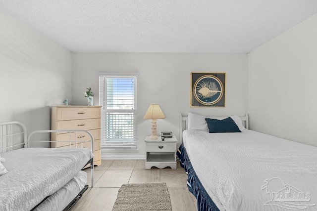 bedroom featuring a textured ceiling and light tile patterned floors