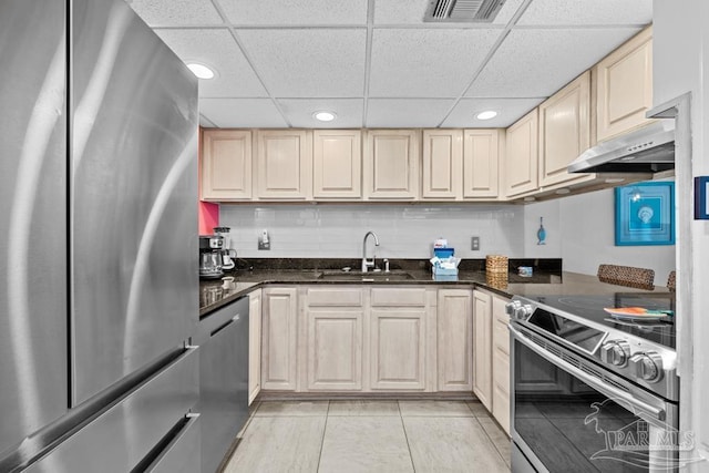 kitchen featuring tasteful backsplash, sink, stainless steel appliances, and dark stone counters