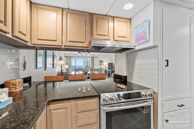 kitchen with tasteful backsplash, stainless steel electric stove, light brown cabinets, and dark stone counters