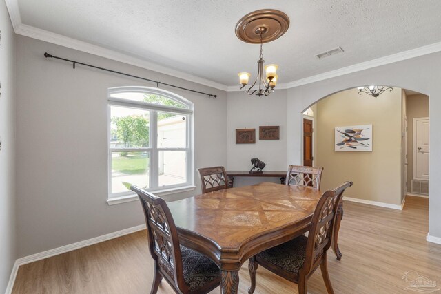 1124 Willowood Cir, Gulf Breeze, FL 32563 - dining area with arched walkways, visible vents, light wood-type flooring, and an inviting chandelier