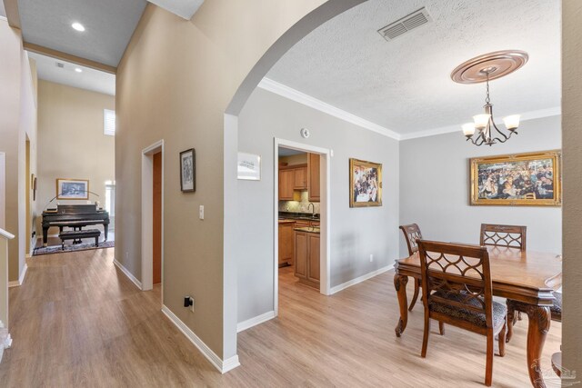 1124 Willowood Cir, Gulf Breeze, FL 32563 - dining area with arched walkways, visible vents, ornamental molding, and light wood-style flooring