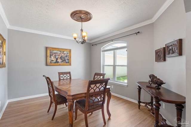 1124 Willowood Cir, Gulf Breeze, FL 32563 - dining area featuring ornamental molding, light wood-style flooring, a chandelier, and a textured ceiling