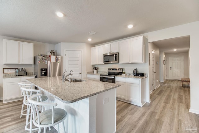 10885 Blacktail Loop, Pensacola, FL 32526 - kitchen with stainless steel appliances, a sink, light wood-style floors, recessed lighting, and a textured ceiling