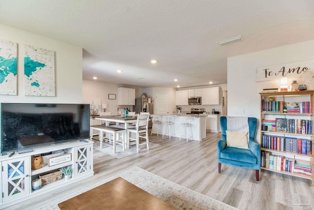 10885 Blacktail Loop, Pensacola, FL 32526 - living room with light wood finished floors, recessed lighting, and a textured ceiling