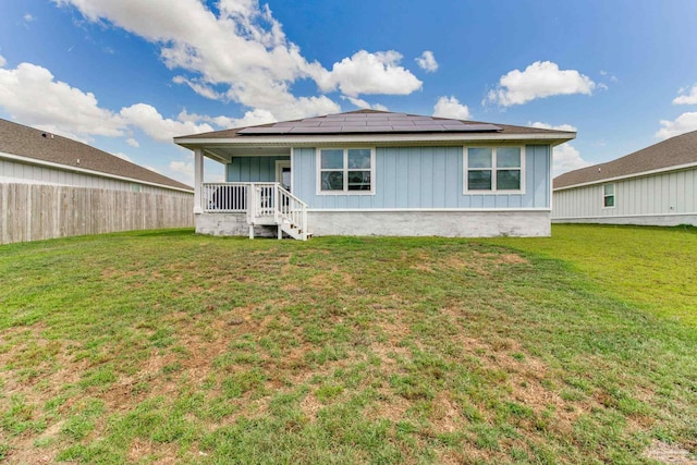 10885 Blacktail Loop, Pensacola, FL 32526 - rear view of property with board and batten siding, roof mounted solar panels, and a porch