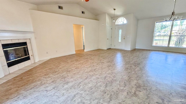 unfurnished living room with high vaulted ceiling, ceiling fan with notable chandelier, and a tile fireplace