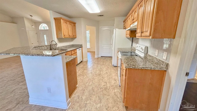 kitchen featuring sink, white appliances, kitchen peninsula, and dark stone counters