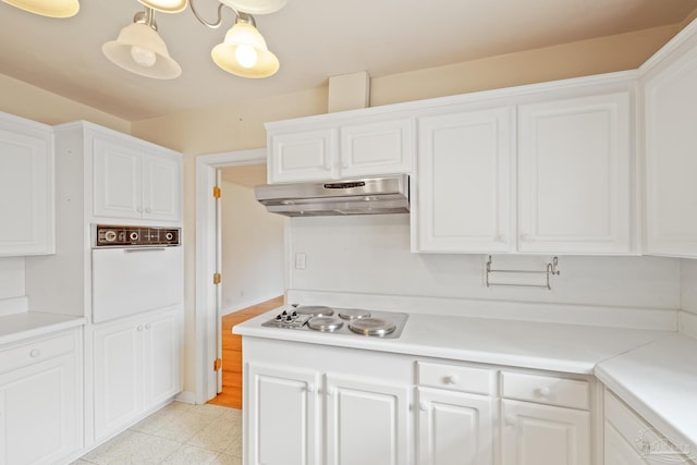 3570 Firestone Blvd, Pensacola, FL 32503 - kitchen with light countertops, under cabinet range hood, stainless steel electric stovetop, white cabinets, and oven