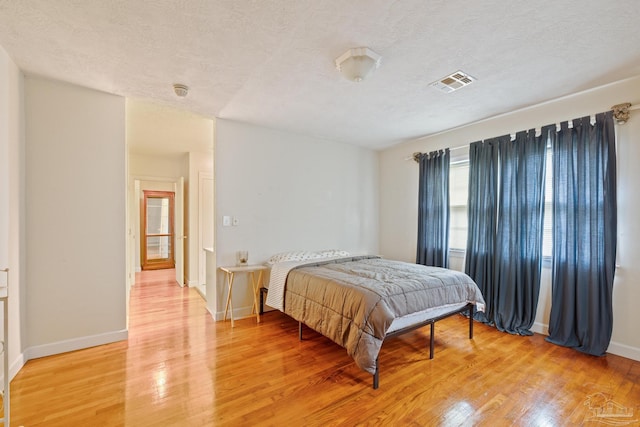 3570 Firestone Blvd, Pensacola, FL 32503 - bedroom with light wood finished floors, baseboards, visible vents, and a textured ceiling
