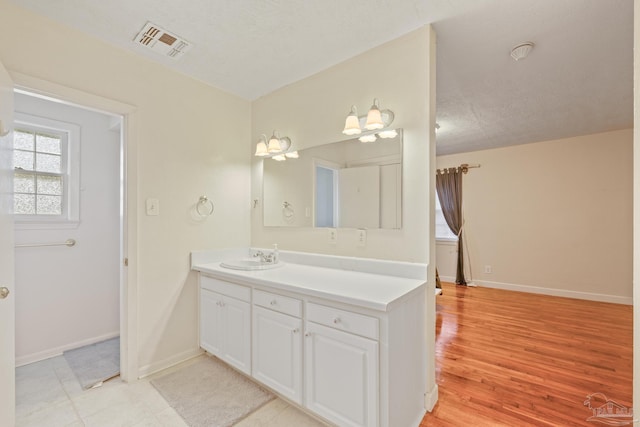 3570 Firestone Blvd, Pensacola, FL 32503 - bathroom with vanity, baseboards, a textured ceiling, visible vents, and wood finished floors