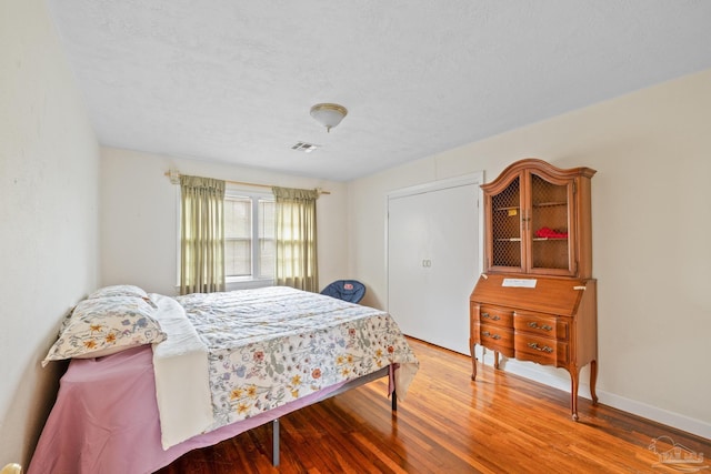 3570 Firestone Blvd, Pensacola, FL 32503 - bedroom with wood finished floors, a textured ceiling, baseboards, and visible vents