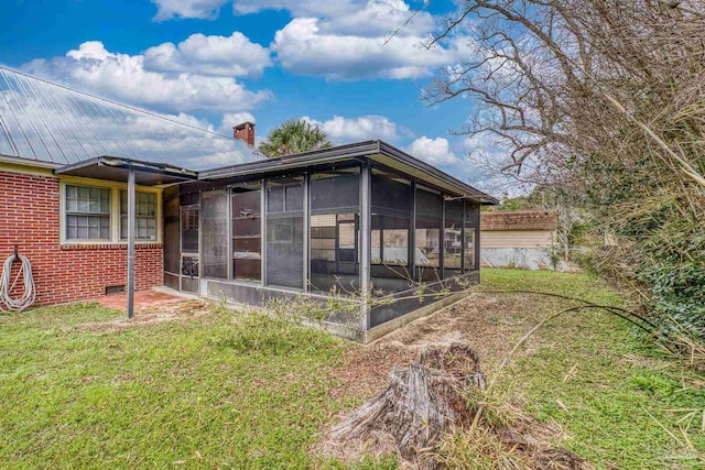 3570 Firestone Blvd, Pensacola, FL 32503 - view of side of property with a sunroom, a chimney, brick siding, and a yard