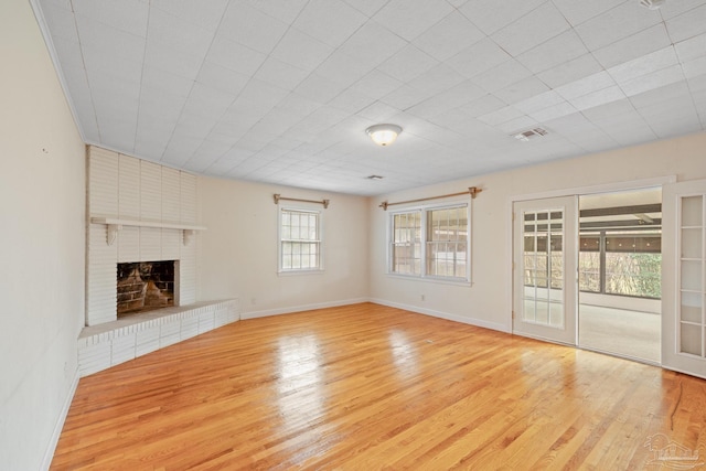 3570 Firestone Blvd, Pensacola, FL 32503 - unfurnished living room featuring baseboards, visible vents, wood finished floors, and a brick fireplace