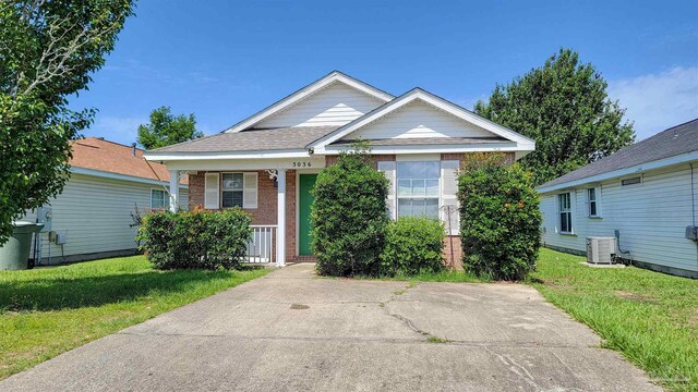 3036 Flintlock Dr, Pensacola, FL 32526 - view of front of house with brick siding, cooling unit, covered porch, and a front lawn