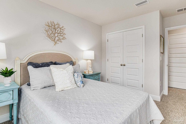 bedroom featuring baseboards, visible vents, carpet floors, and a closet