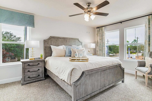 carpeted bedroom with baseboards, multiple windows, and ceiling fan