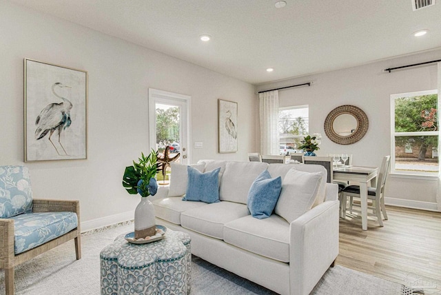 living area featuring recessed lighting, visible vents, baseboards, and light wood finished floors