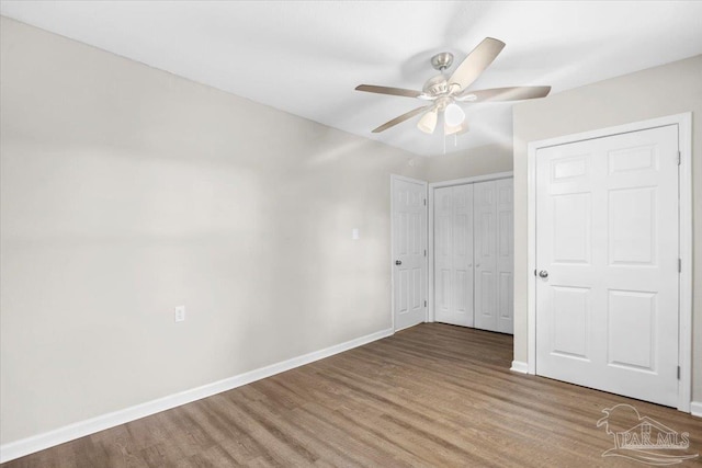 unfurnished bedroom featuring hardwood / wood-style flooring, ceiling fan, and a closet