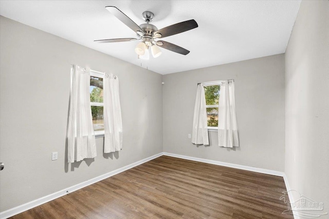 spare room featuring dark wood-type flooring and ceiling fan