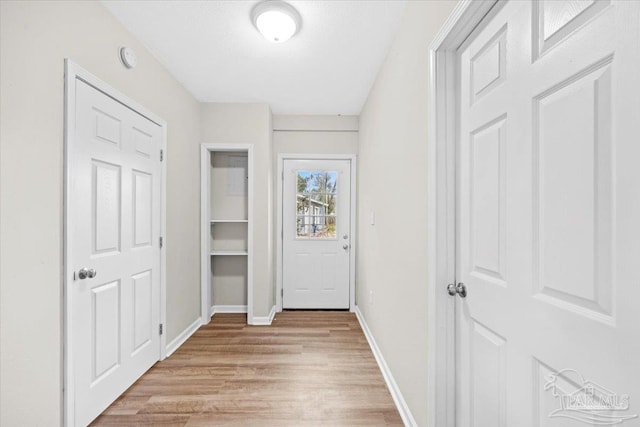 hallway with light hardwood / wood-style floors