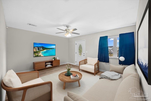 living room featuring hardwood / wood-style floors and ceiling fan