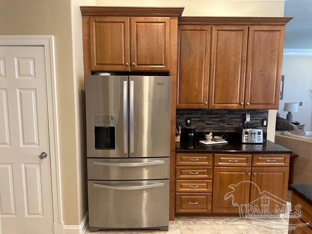 1988 Heritage Park Way, Navarre, FL 32566 - kitchen with stainless steel fridge with ice dispenser, brown cabinets, and tasteful backsplash