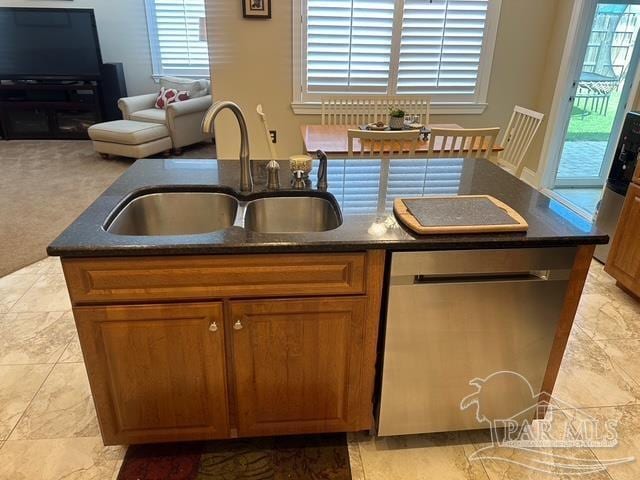 1988 Heritage Park Way, Navarre, FL 32566 - kitchen featuring dishwasher, a sink, brown cabinets, a center island with sink, and open floor plan