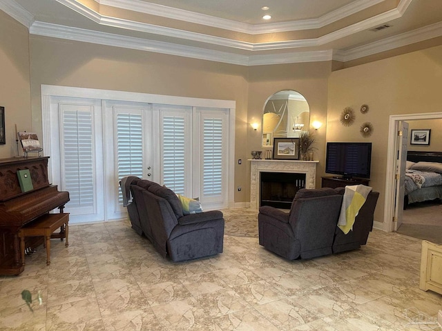 1988 Heritage Park Way, Navarre, FL 32566 - living area with a tray ceiling, a fireplace, crown molding, arched walkways, and baseboards