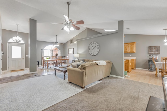 living room with lofted ceiling, a ceiling fan, baseboards, and light carpet