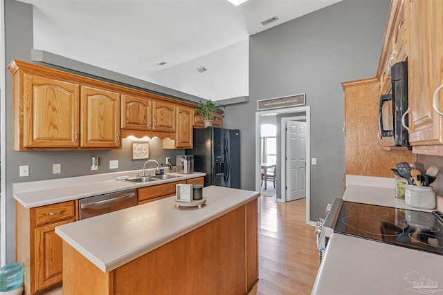 kitchen featuring a sink, visible vents, light countertops, high vaulted ceiling, and black appliances