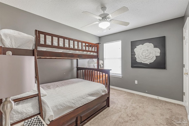 carpeted bedroom with a ceiling fan, baseboards, and a textured ceiling