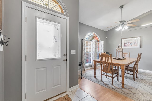 foyer entrance featuring lofted ceiling, a ceiling fan, and baseboards