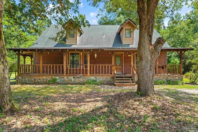 view of front of house featuring covered porch and a shingled roof