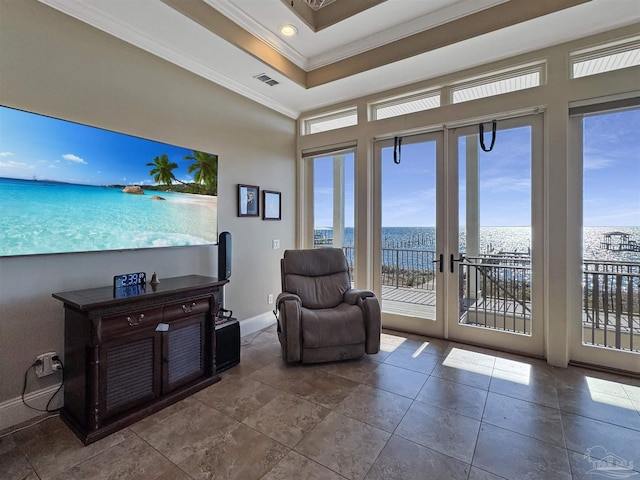 interior space featuring baseboards, visible vents, a water view, a tray ceiling, and crown molding