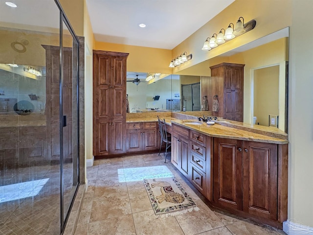 full bath with ceiling fan, toilet, a stall shower, and vanity