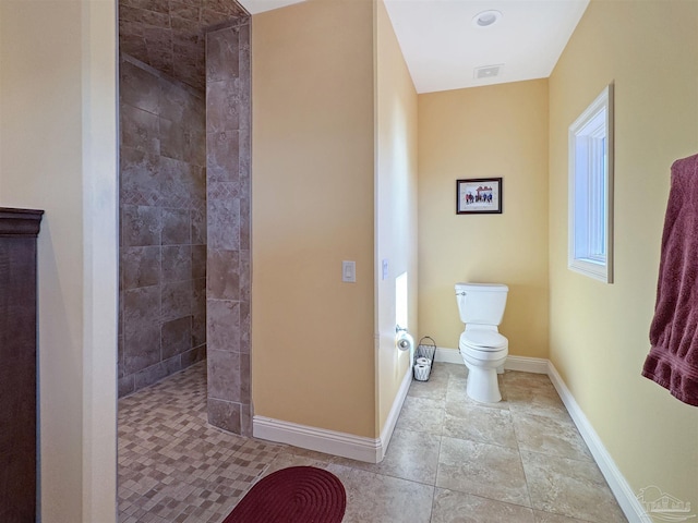 bathroom with tile patterned flooring, toilet, visible vents, baseboards, and walk in shower